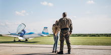 Girl standing with father in front of plane